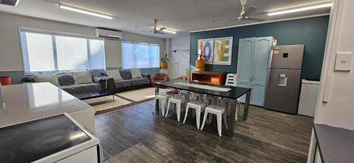 a kitchen and living room with a table and a couch at Arty Apartments in Tauranga