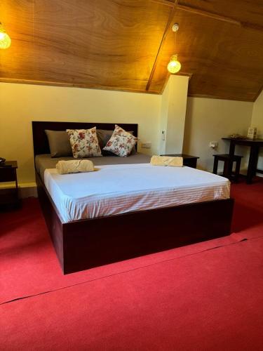 a large bed in a room with a red carpet at Steps Garden Resort in Negombo