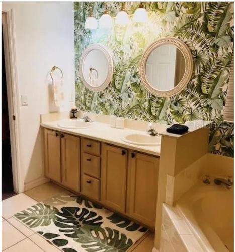 a bathroom with a sink and two mirrors at Enchanted Disney Vacation Villa in Kissimmee