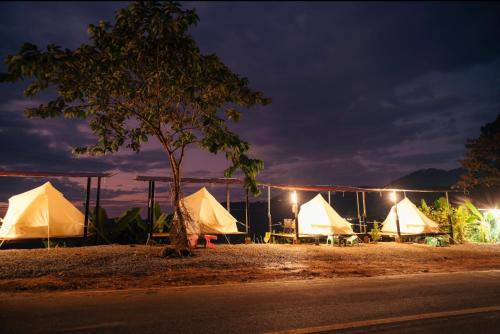 a group of tents on the side of the road at night at The will glamping&camping in Ban Na Pho