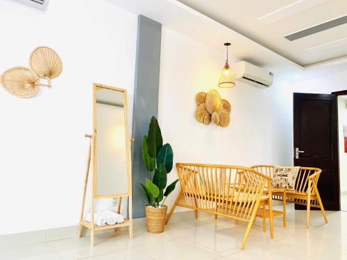 una sala da pranzo con tavolo, sedie e uno specchio di Hà Đan Hotel - Bãi Sau Vũng Tàu a Vung Tau