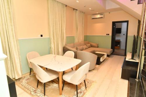 a living room with a table and chairs and a couch at 4 bedroom Luxury Apartment in Lagos