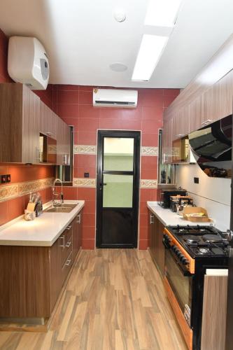 a large kitchen with red walls and wooden cabinets at 4 bedroom Luxury Apartment in Lagos