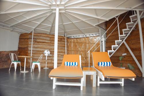 two chairs and a table in a room at Nest By Craftels, Goa in Cola