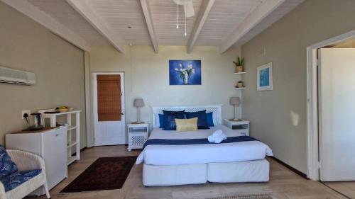 a bedroom with a large bed with blue pillows at Whales Way Ocean Retreat in Wilderness
