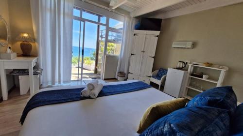 a bedroom with a bed and a large window at Whales Way Ocean Retreat in Wilderness