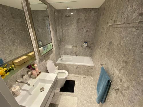 a bathroom with a sink and a toilet and a tub at Marina Front Qbed Ensuite Room For Dog Lovers in Shellharbour