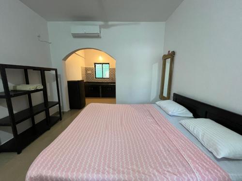 a bedroom with a large bed with a pink mattress at God's Gift Morjim in Morjim