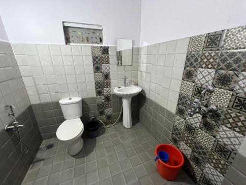 a bathroom with a toilet and a sink at God's Gift Morjim in Morjim