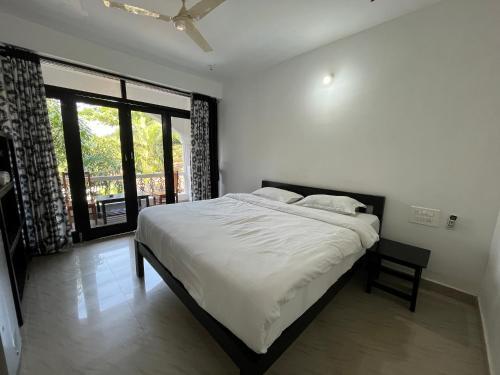 a bedroom with a bed and a large window at God's Gift Morjim in Morjim