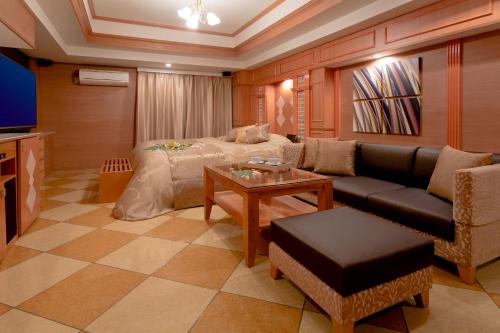 a living room with a couch and a tv at ホテルウォーターゲート岡山 in Okayama
