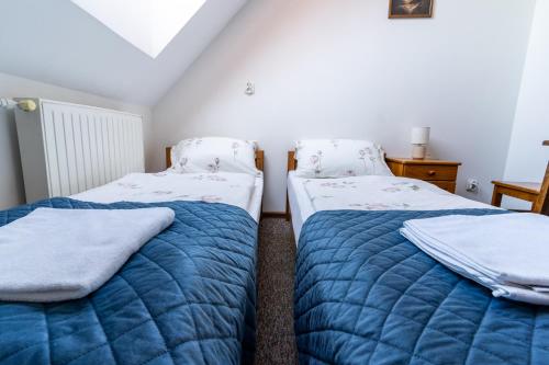 two beds in a room with blue blankets at Base Camp Pieniny in Niedzica