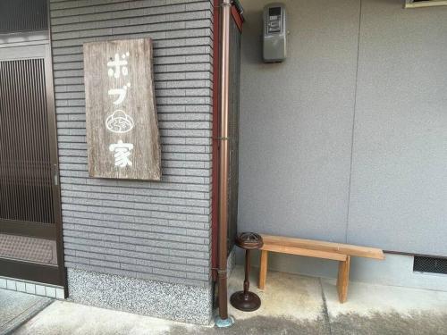 a sign on the side of a building with a bench at Bob's house in Kameoka