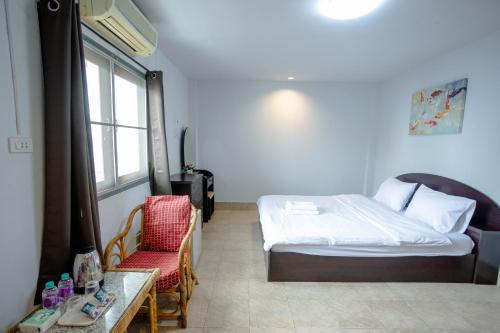 Un dormitorio con una cama, una mesa y una silla. en Mitr Inn HuaHin Beach, en Hua Hin