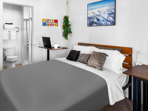 ein weißes Schlafzimmer mit einem Bett und einem Laptop auf einem Schreibtisch in der Unterkunft Downtown San Jose Priv Entry Priv Bath SJSU and AC in San Jose