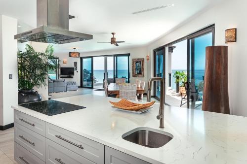a kitchen with a sink and a counter with a view of the ocean at Tamarind Hills Resort & Villas in Johnsons Point