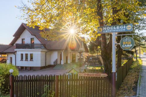 a sign in front of a house with a fence at Base Camp Pieniny in Niedzica