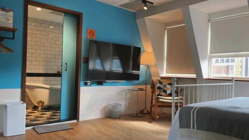 a bedroom with a bed and a tv and a tub at Chill Roof Hotel in Taipei