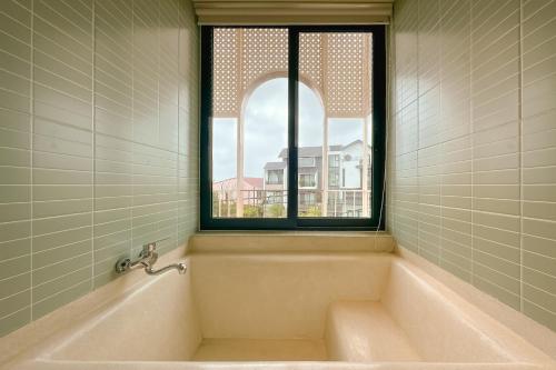 会安Palmera Hoi An Villa & Apartment的带窗户的浴室里的浴缸