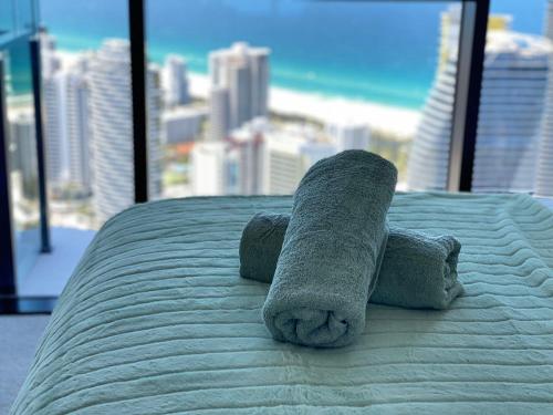 a stuffed animal on a bed with a view of the beach at La Jolla Holiday Broadbeach in Gold Coast