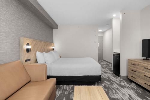 a hotel room with a bed and a couch at Sandman Hotel Calgary Airport in Calgary
