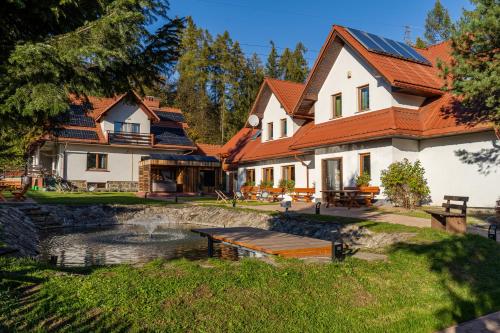 a house with a pond in the yard at Base Camp Pieniny in Niedzica