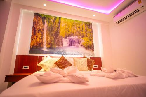 a bedroom with a bed with a painting on the wall at J60 Suites, Ashok Vihar - Near Netaji Subhash Place in New Delhi