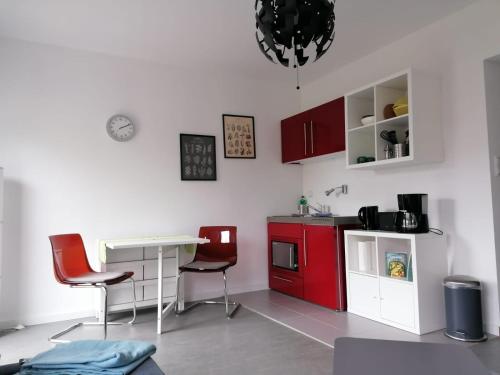 a kitchen with red cabinets and a table and chairs at Haus Charlottenburg 1, zentrumsnah gelegen, mit Blick auf die Festung in Königstein an der Elbe