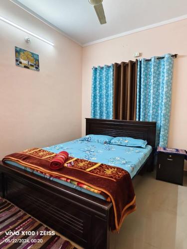 a bed in a bedroom with blue curtains at ZTRIO Vacations in Chikmagalūr