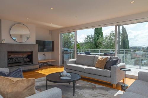 a living room with a couch and a fireplace at Welcome to Luxury Living in CBD Near Mission Bay in Auckland