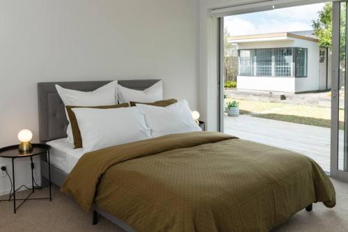 a bedroom with a large bed and a sliding glass door at Welcome to Luxury Living in CBD Near Mission Bay in Auckland
