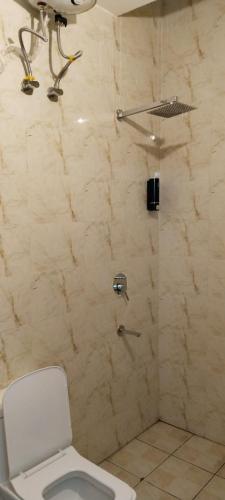 a bathroom with a shower with a toilet at The Gange Hill By Green Bird Hospitality in Rishīkesh