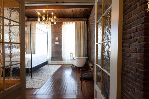 a bedroom with a bed and a tub in a room at Hotel Cleo, Knoxville Downtown, a Tribute Portfolio Hotel in Knoxville