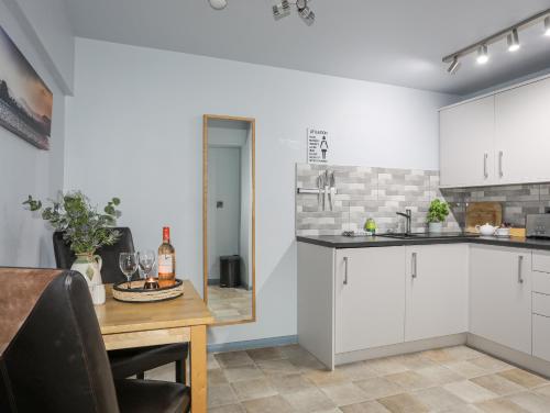 a kitchen with white cabinets and a wooden table at Vyrnwy Lakeside - Bala Lake in Bala