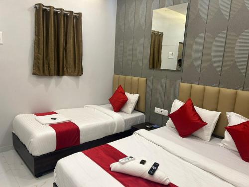 a hotel room with two beds and a mirror at Hotel Vaithi Residency - Andheri West in Mumbai