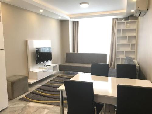 a living room with a table and chairs and a couch at Kuzey Adana'da merkezi konumda in Kurttepe