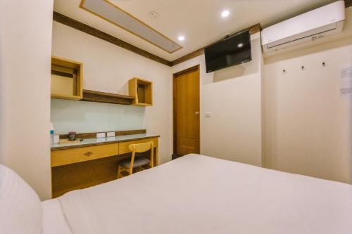 a room with a bed and a desk and a television at 許家古宅 4-6人包棟民宿 in Tainan