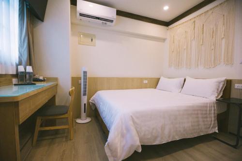 a hotel room with a bed and a desk and a bed sidx sidx at 許家古宅 4-6人包棟民宿 in Tainan