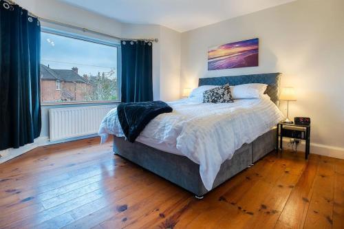 a bedroom with a bed and a large window at 4 double bedrooms Lux Villa in Malone Belfast in Belfast