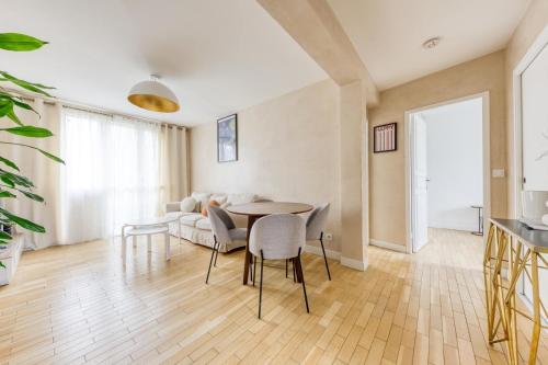 un salon avec un canapé, une table et des chaises dans l'établissement Bel appartement lumineux proche Paris, à Cachan