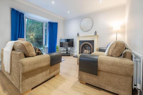 a living room with two chairs and a fireplace at 4 double bedrooms Lux Villa in Malone Belfast in Belfast