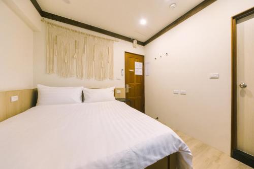 a bedroom with a white bed and a window at 許家古宅 4-6人包棟民宿 in Tainan