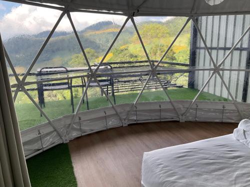 a room with a bed and a large window at The will glamping&camping in Ban Na Pho