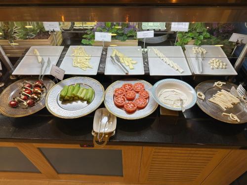 科尼亚Grand Millennium Konya的餐桌上的自助餐,包括盘子