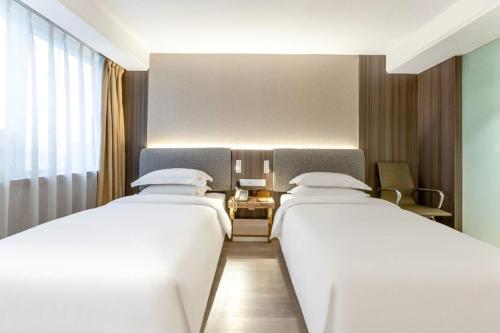 Katil atau katil-katil dalam bilik di Jinan Yuquan Simpson Hotel