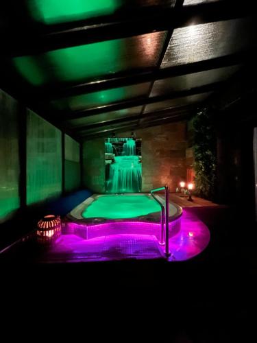 a dark room with a hot tub with purple lights at Apartment Roku 2024 - JELEŃ & NATURA in Kudowa-Zdrój