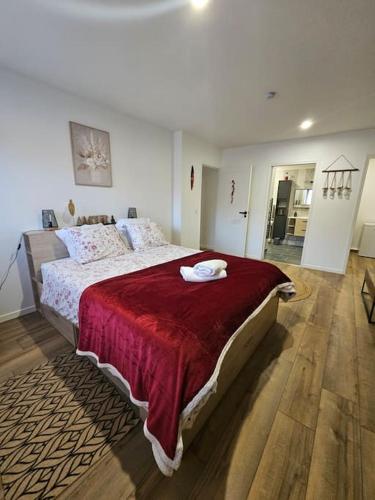 une chambre avec un grand lit avec une couverture rouge dans l'établissement Chambre d'hôte Aphrodite, à Sainte-Geneviève-des-Bois