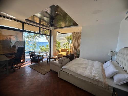 a bedroom with a bed and a view of the ocean at The French Villa-Santander Cebu in Santander
