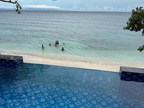 a group of people in the water at the beach at The French Villa-Santander Cebu in Santander