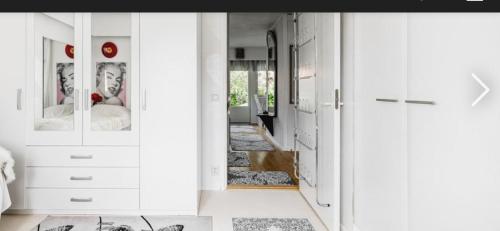 a bedroom with white cabinets and a hallway at Paukavuori in Seinäjoki
